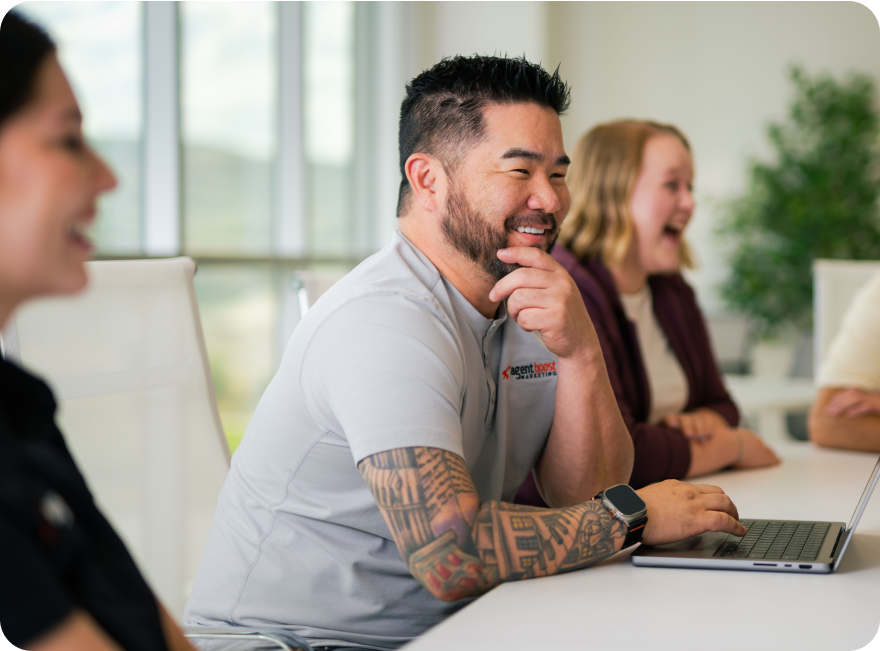 Colleagues laughing around meeting table